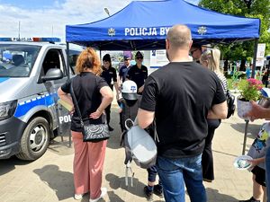 na zdjęciu stoisko policyjne, przy nim dwie policjantki i zgromadzone osoby