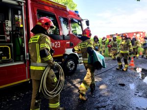na zdjęciu strażacy idący w stronę pociągu