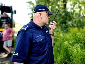 na zdjęciu zastępca komendanta trzyma w dłoni radiostację tuż przy ustach