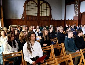 na zdjęciu młodzież siedząca na krzesłach w sali