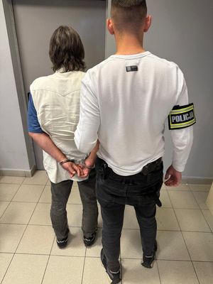 na zdjęciu mężczyzna w kajdankach i nieumundurowany policjant