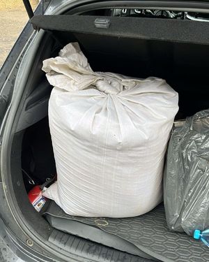 na zdjęciu worek białego koloru w bagażniku pojazdu