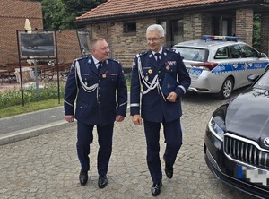 na zdjęciu komendant wojewódzki i bytomski idą razem, za nimi radiowóz