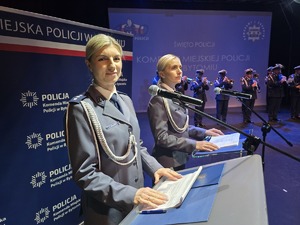 na zdjęciu dwie policjantki przy mównicach, za nimi występ orkiestry policyjnej
