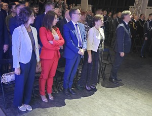 stojący zgromadzeni goście i mundurowi