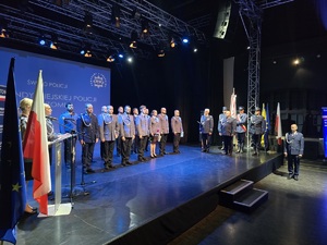 stojący na scenie mundurowi po gratulacjach od komendanta wojewódzkiego i miejskiego