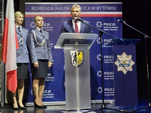 Prezydent Miasta Bytomia przy mównicy, obok dwie policjantki