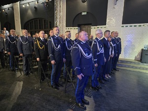 mundurowi i goście stojący na sali