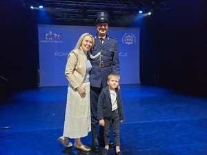 policjant przytula kobietę przy nich kilkuletni chłopiec