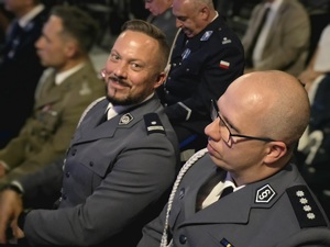na zdjęciu dwóch siedzących mundurowych pośród zgromadzonych gości