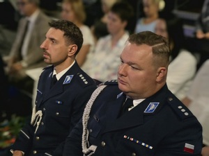 na zdjęciu dwóch siedzących mundurowych pośród zgromadzonych gości