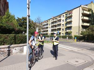 na zdjęciu rowerzysta obok dwóch policjantów