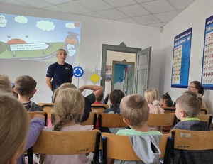 na zdjęciu policjantka przed nią dzieci siedzące na krzesłach