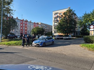 na zdjęciu trzech policjantów obok radiowozu
