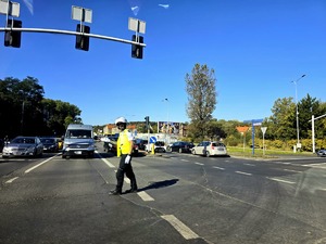 policjant na skrzyżowaniu, wskazuje ręką kierunek jazdy