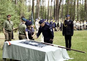 na zdjęciu komendant wbija młotkiem gwóźdź w drzewiec sztandaru