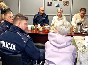 na zdjęciu siedzący przy stole policjanci i pedagodzy, kuratorzy i pracownicy socjalni