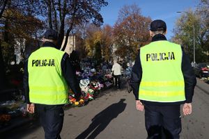na zdjęciu policjanci przy cmentarzu