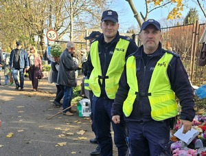 na zdjęciu policjanci przy cmentarzu