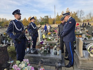 policjanci i starszy mężczyzna przy grobie poległego policjanta