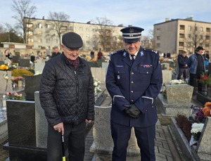 policjant i starszy mężczyzna przy grobie poległego policjanta
