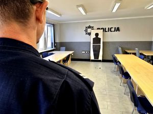 na zdjęciu ramię policjanta, przed nim tarcza