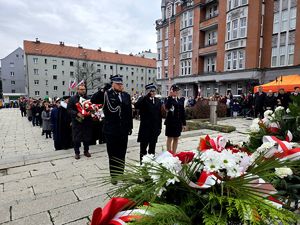 na zdjęciu osoby stojące przed pomnikiem Wolności