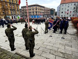 na zdjęciu salutujący mundurowi i zgromadzone osoby
