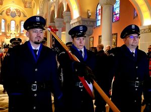 na zdjęciu policjanci wychodzący z kościoła ze sztandarem