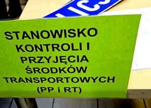 na zdjęciu na stole żółta kartka na niej napis stanowisko kontroli przyjęcia środków transportu