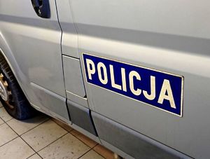 na zdjęciu na szarym samochodzie naklejony napis Policja