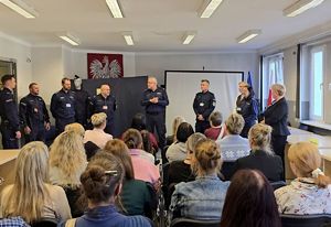 na zdjęciu zastępca bytomskiego komendanta kilku policjantów oraz siedzące przed nimi na krzesłach osoby