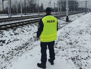 na zdjęciu policjant obok torów kolejowych