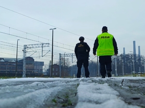 na zdjęciu policjant i funkcjonariusz Straży Ochrony Kolei stoją przy torowisku