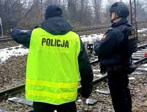 policjant i funkcjonariusz Straży Ochrony Kolei przy torach kolejowych
