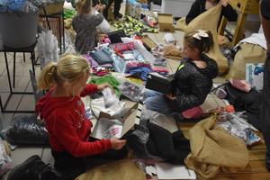 na zdjęciu dzieci w trakcie rozpakowywania prezentów