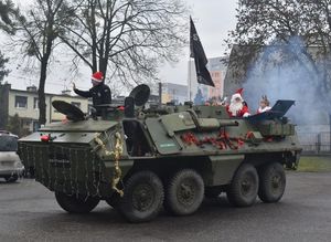 na zdjęciu wóz militarny i mundurowi w czapkach mikołajowych