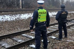 policjant i funkcjonariusz Straży Ochrony Kolei przy torach kolejowych