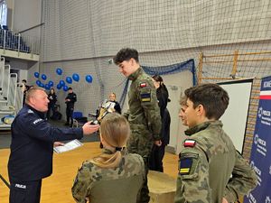 na zdjęciu bytomski komendant wręczający puchar i dyplom drużynie na drugim miejscu podium