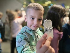 chłopiec trzyma w dłoni odblaskowy element z napisem Policja