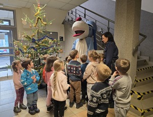 dzieci, ich opiekunowie i policjanci ubierający choinkę