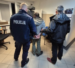 zatrzymany mężczyzna trzymany przez dwóch policjantów