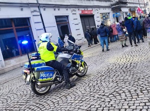 policjanci na motocyklach służbowych na rynku, obok zgromadzone osoby