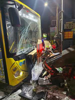 na zdjęciu kolizja dwóch pojazdów, przód autobusu z rozbitą szybą czołową, przed nim tył śmieciarki