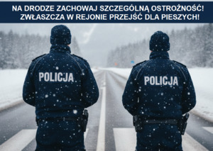 na zdjęciu pośród śniegu dwóch policjantów przed przejściem dla pieszych, nad nimi napis na drodze zachowaj szczególną ostrożność zwłaszcza w rejonie przejść dla pieszych