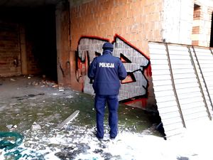 na zdjęciu policjant przy pustostanie