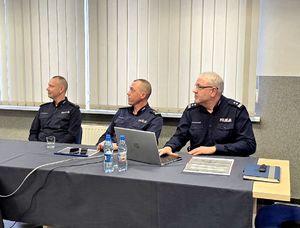 na zdjęciu trzej policjanci siedzący w sali na krzesłach