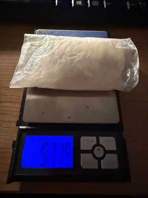 na zdjęciu waga, na niej biały proszek w przezroczystym worku