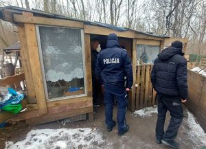 na zdjęciu policjant przy altanie, przy nim dwóch mężczyzn