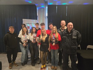 na zdjęciu policjant i osoby pozujące do zdjęcia